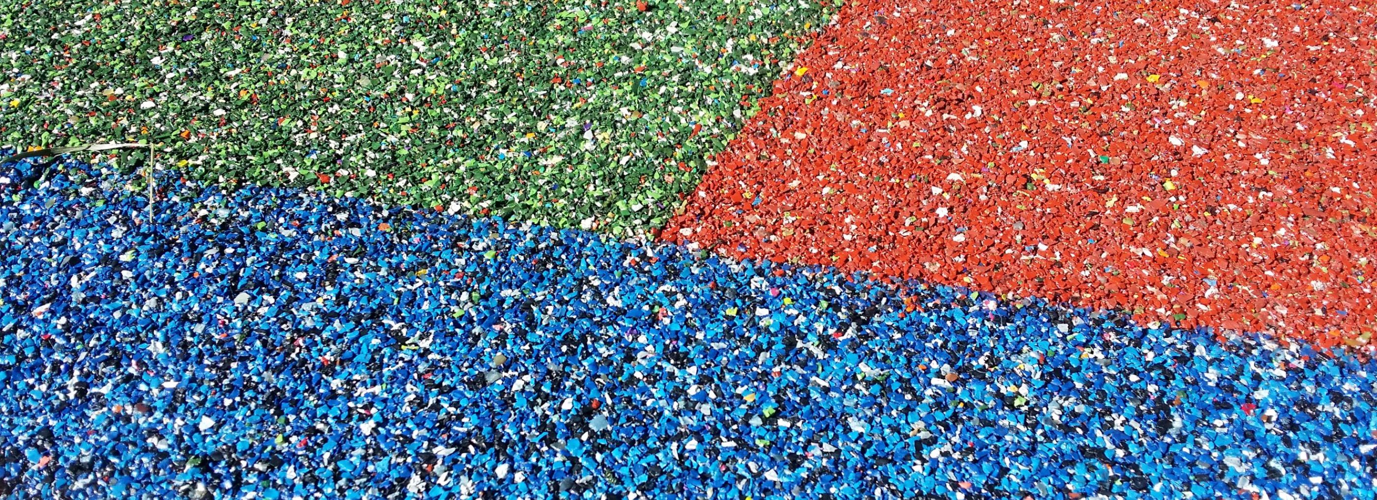 Close up of rubber playground in three colours; blue, green and red.