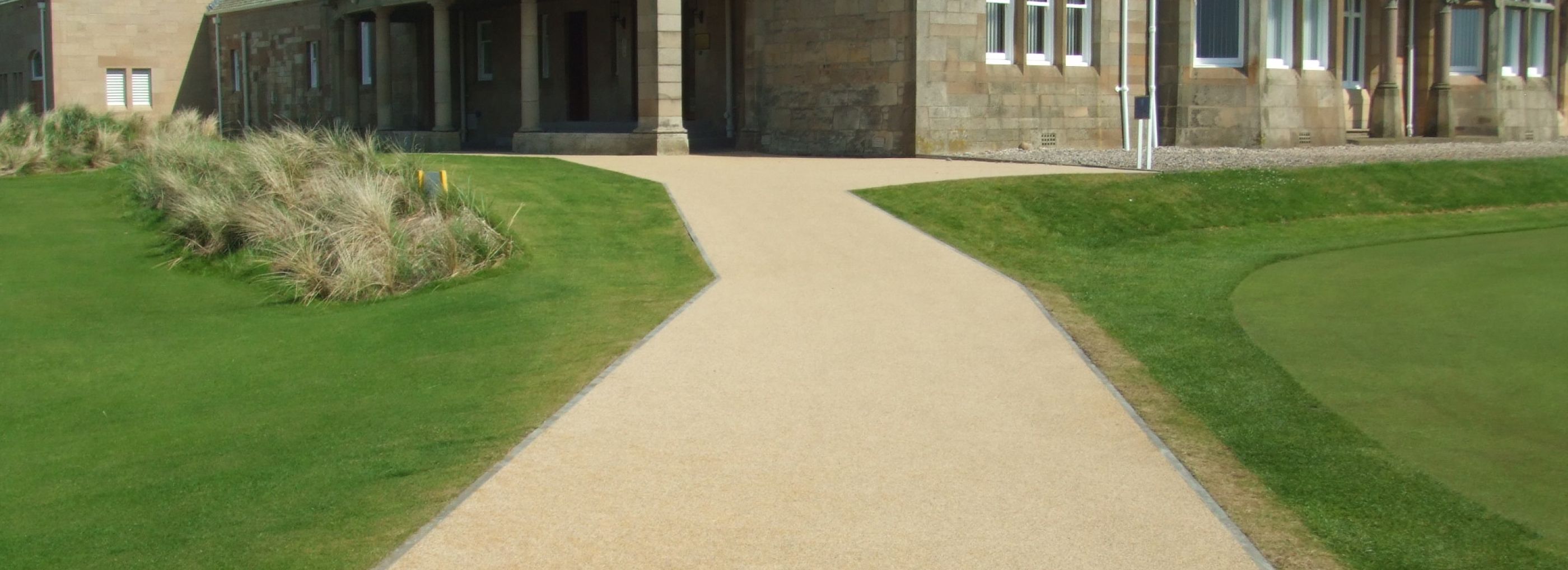 Rubber walkway path towards a grand stone building.