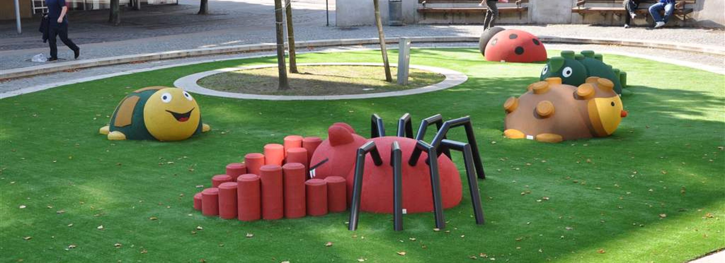Outdoor playground with a range of 3D play animals including a spider, ladybird and reptile.